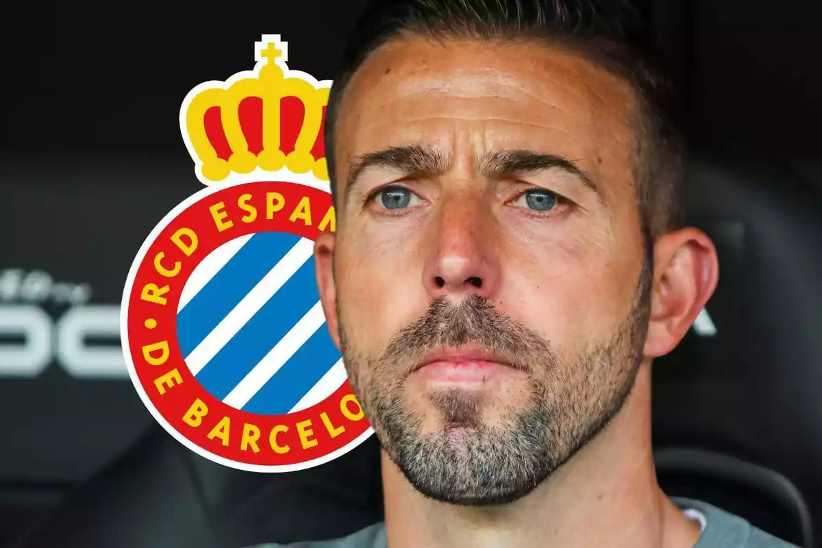 Luis García con la mirada perdida junto a un escudo del RCD Espanyol